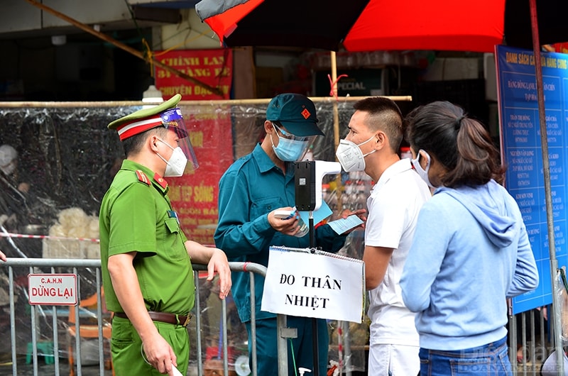 Người dân vào chợ phải có phiếu đi chợ, đo thân nhiệt mới được vào mua sắm.