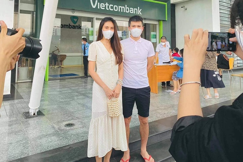 Hai vợ chồng Công Vinh - Thủy Tiên đứng trước cửa ngân hàng Vietcombank, nơi lấy sao kê tài khoản từ thiện.