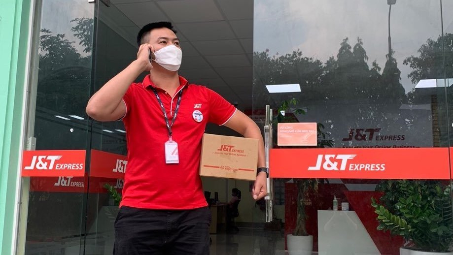 Các shipper J&T Express được tiêm phòng và có đeo huy hiệu đã tiêm vaccine ngừa Covid-19
