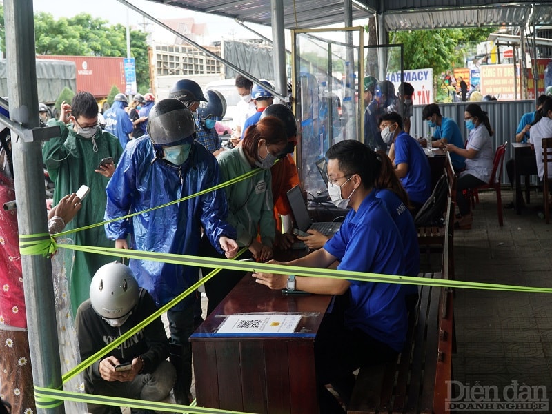 Lực lượng tình nguyện tại các chốt kiểm soát hướng dẫn người dân khai báo trực tuyến.