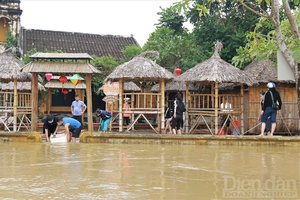 Khi nước lũ có dấu hiệu rút, người dân tranh thủ dọn dẹp bùn non.