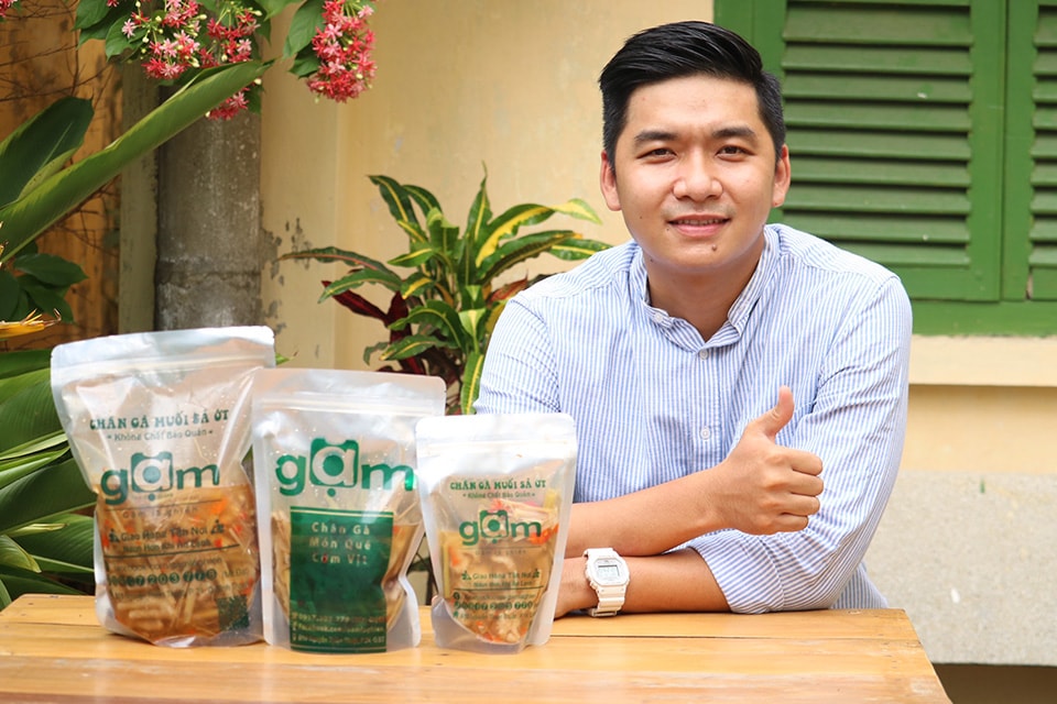 Anh Phan Phạm Tấn Đạt bên sản phẩm chân gà muối sả ớt, món ăn làm nên thương hiệu cho riêng anh trong thị trường thực phẩm. Ảnh: An Phú
