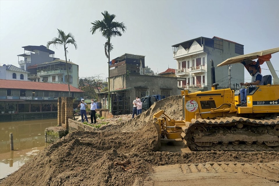 Máy ủi đất san lấp hồ Bà Đồ. Ảnh: TG