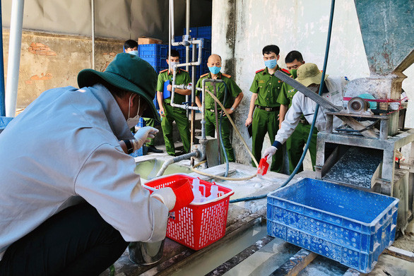 Đại diện Sở Tài nguyên - môi trường Đồng Nai lấy mẫu nước thải khu vực máy xay nghiền bóng đèn thải trong Xí nghiệp đèn ống - Ảnh: B.A.