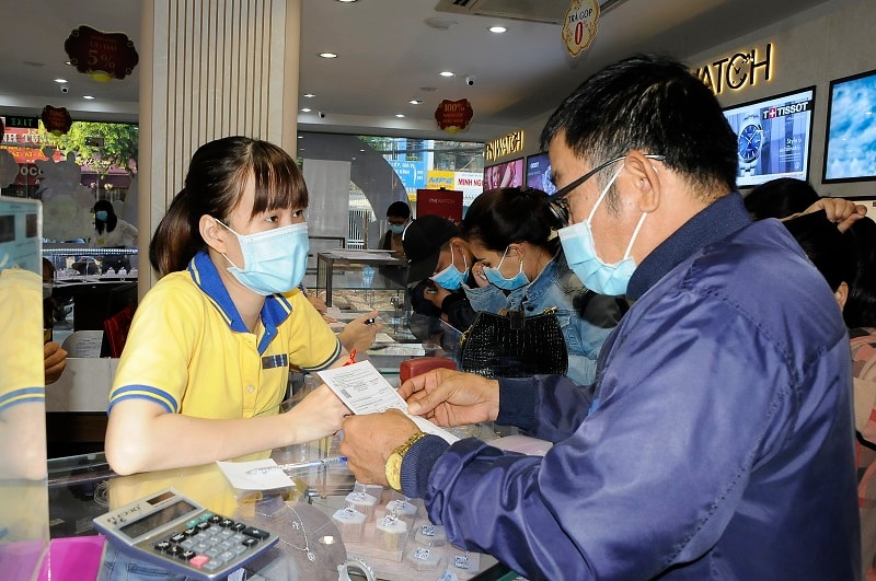 Nhân viên PNJ tư vấn cho khách hàng mua vàng vào ngày Thần Tài tại cửa hàng PNJ trên đường Trường Chinh, quận Tân Bình - Ảnh: Đình Đại.