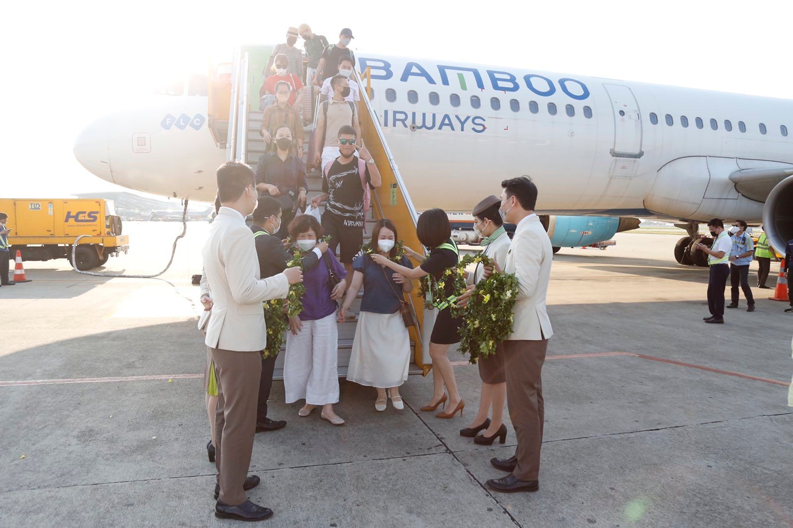 Ảnh 2: Hành khách tham gia chuyến bay nhận hoa chào mừng từ đại diện Bamboo Airways