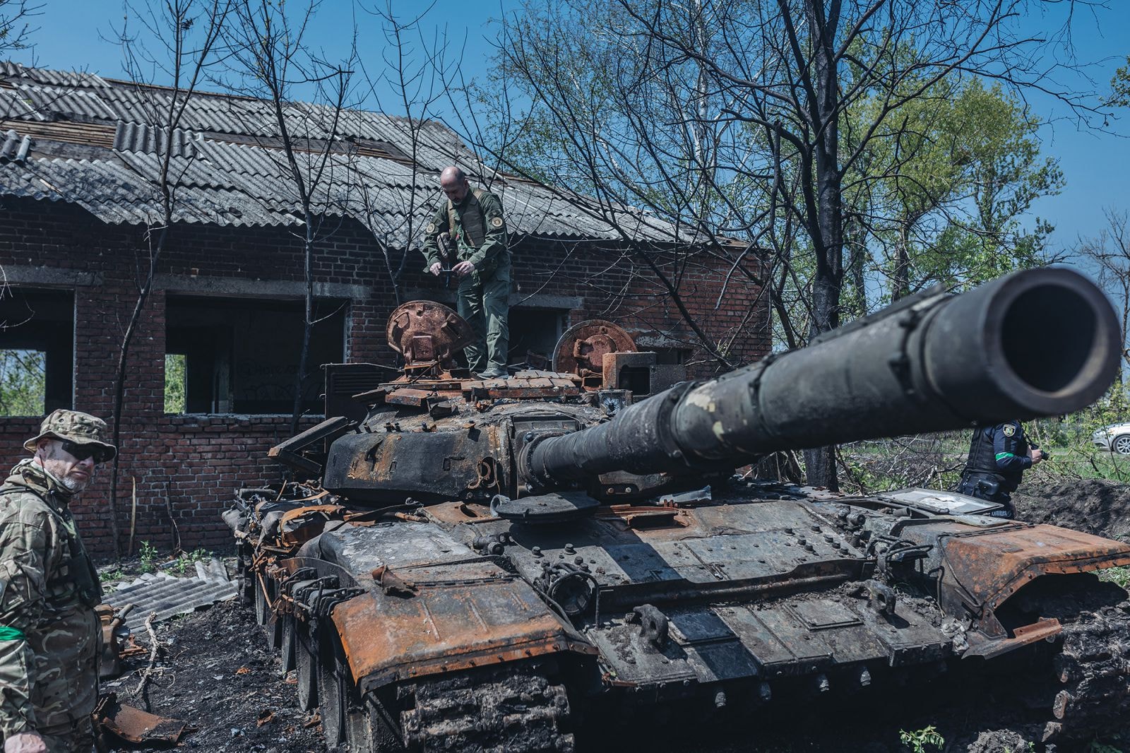 Binh sĩ Ukraine bên cạnh một chiếc xe tăng Nga bị phá hủy ở ngoại ô Kharkiv, Ukraine, ngày 8/5. (Diego Herrera Carcedo / Anadolu Agency / Getty Images)