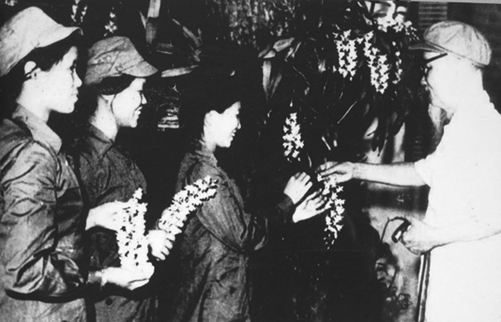 Chủ tịch Hồ Chí Minh tặng hoa phong lan cho ba đại biểu nữ dân quân Quảng Bình và Vĩnh Linh, năm 1968.