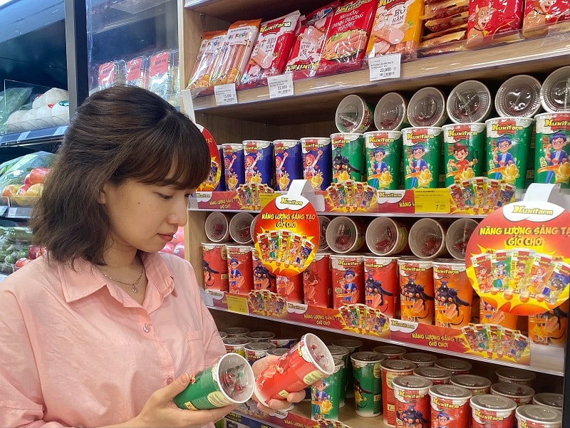 Người tiêu dùng tham khảo thông tin xúc xích Xuxifarm tại siêu thị Nova