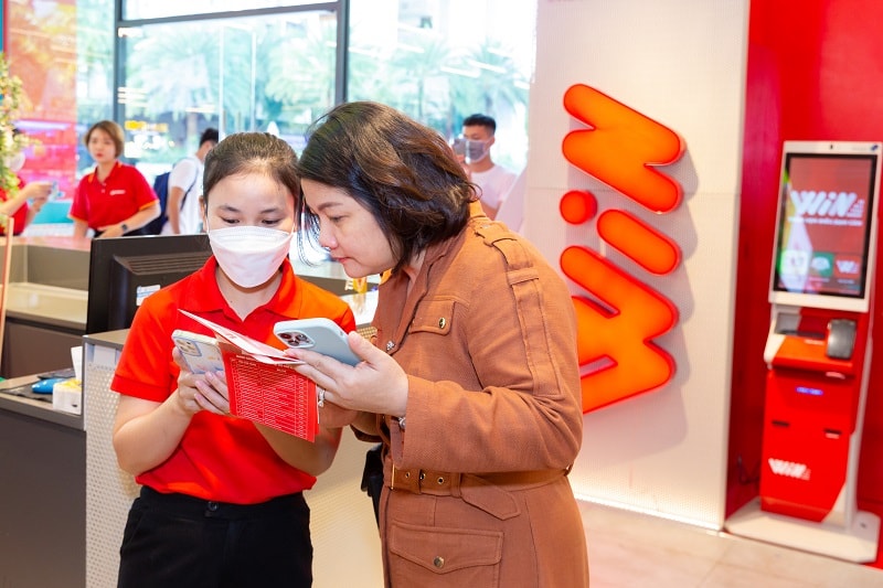 Nhân viên cửa hàng hướng dẫn khách hàng đăng ký hội viên WIN