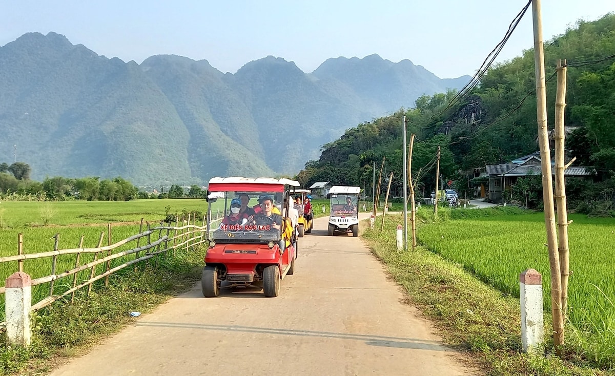 Du khách đi xe điện tham quan bản Lác, xã Chiềng Châu, huyện Mai Châu