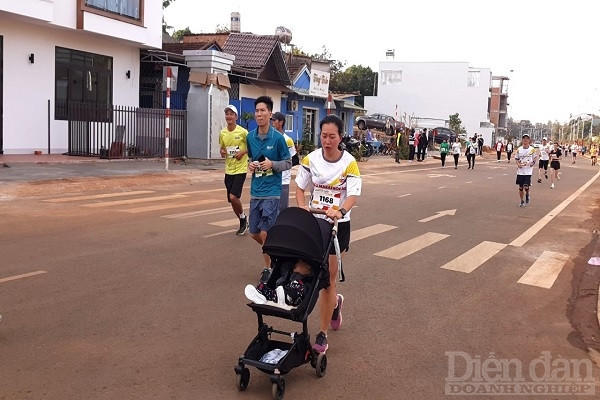 Hình ảnh người mẹ trẻ đem theo con cùng tham gia giải chạy.