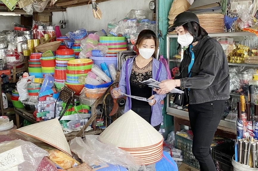 Cán bộ BHXH TP Móng Cái tuyên truyền cho các hộ tiểu thương trên địa bàn tham gia BHXH tự nguyện.