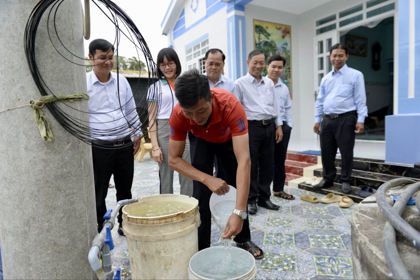 Anh Lê Thanh Phong xã Phú Tân (áo đỏ) vui mừng sử dụng nước sạch