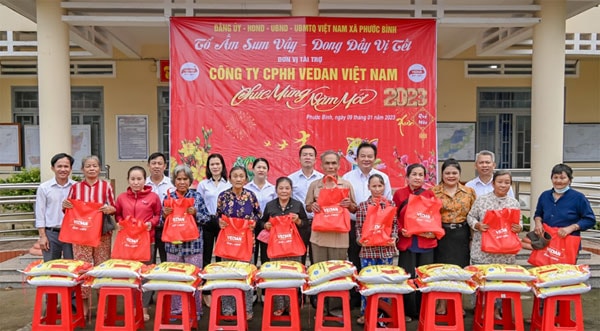 Bà Nguyễn Thu Thuỷ - Phó Giám đốc Đối ngoại Vedan Việt Nam (áo cam) đến trao quà Tết cho người dân tại xã Phước Bình