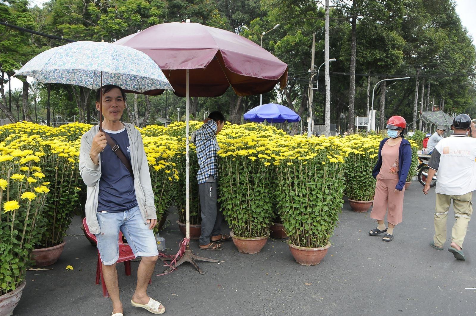 Anh Sơn (cầm ô) không biết sẽ làm gì nếu không bán hết chỗ hoa này.