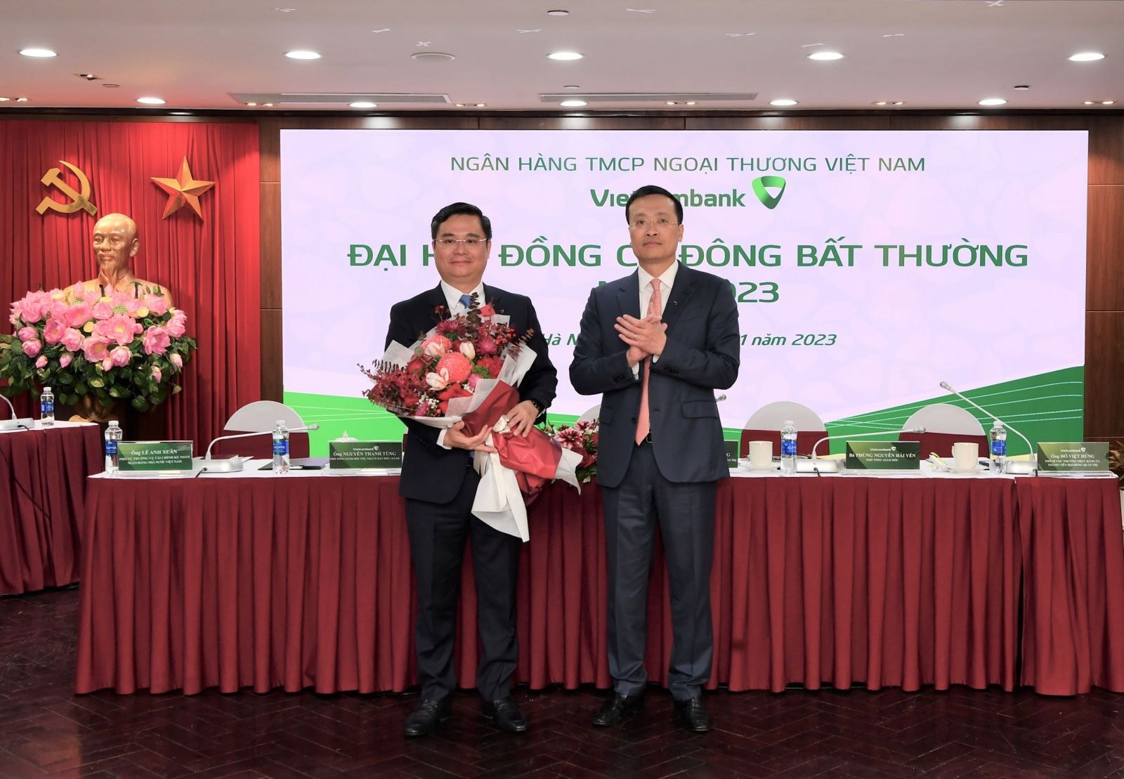 Ông Phạm Quang Dũng - Ủy viên Ban Thường vụ Đảng ủy Khối Doanh nghiệp Trung ương, Bí thư Đảng ủy, Chủ tịch HĐQT Vietcombank (bên phải) giới thiệu và tặng hoa chúc mừng ông Nguyễn Thanh Tùng - Phó Tổng Giám đốc phụ trách Ban điều hành đã được Đại hội bầu bổ sung là Thành viên HĐQT Vietcombank nhiệm kỳ 2018 - 2023