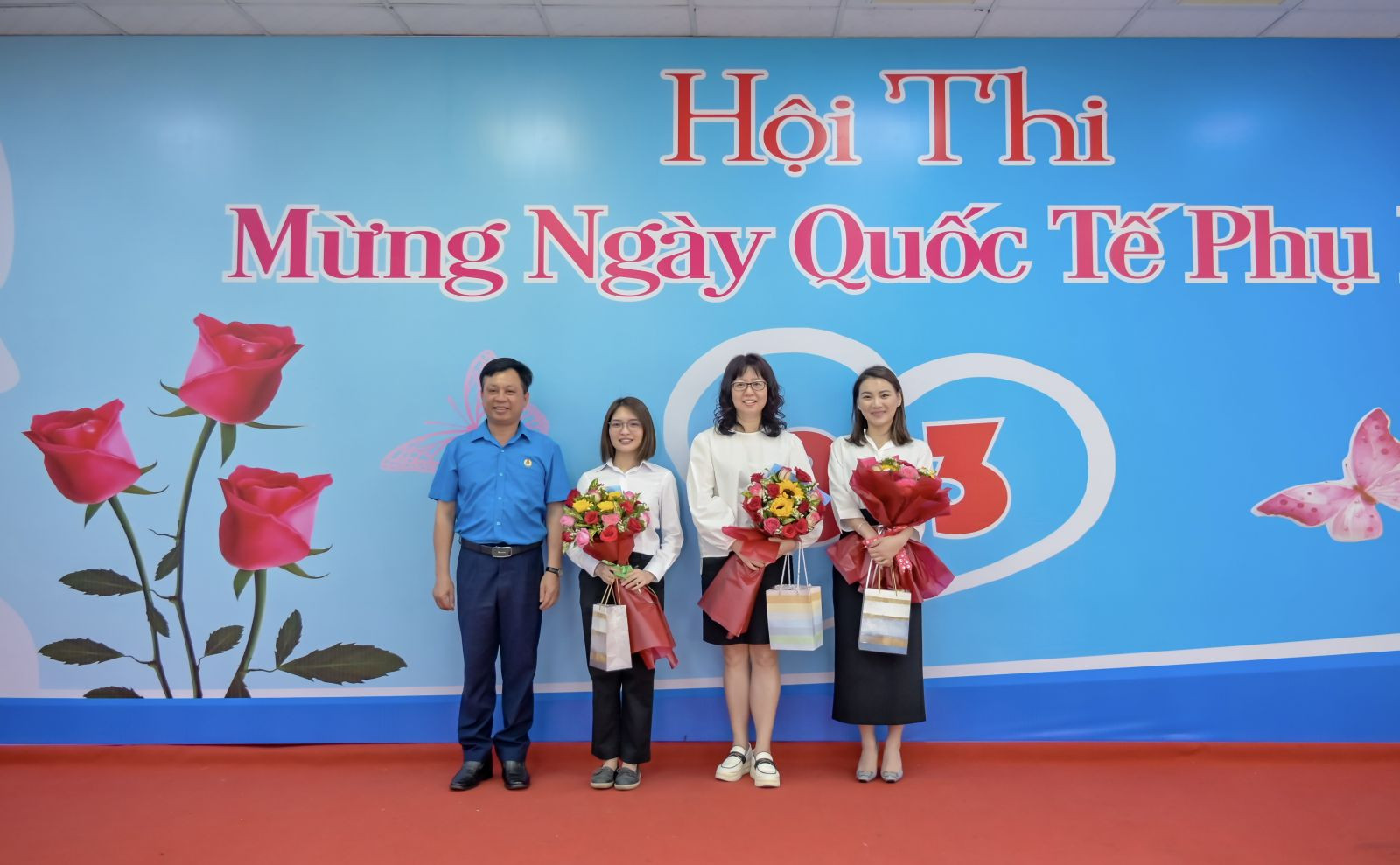    Ông Phạm Trung Thuyên - Chủ tịch Công đoàn (áo xanh) trao hoa và quà cho các nữ cán bộ nhân viên nước ngoài