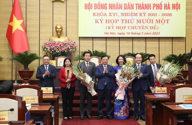 Lãnh đạo TP. Hà Nội tặng hoa cho tân Phó Chủ tịch UBND Vũ Thu Hà (áo dài xanh) và các Ủy viên UBND Thành phố - Ảnh: VGP