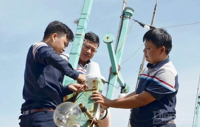 Anh Trần Thái Sơn (ngoài cùng bên phải) cùng các kỹ sư của Công ty tham gia lắp thiết bị giám sát tại các tàu cá