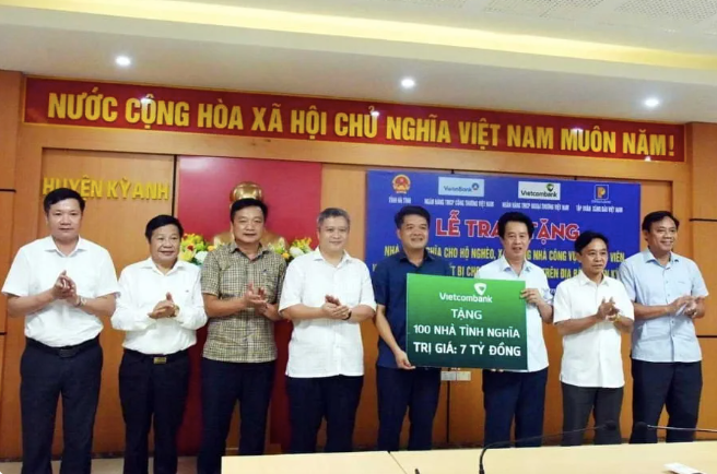 Ông Nguyễn Mỹ Hào - UV BTV Đảng ủy, Thành viên HĐQT Vietcombank (thứ 3, từ phải sang) trao biểu trưng hỗ trợ kinh phí xây dựng 100 căn nhà tình nghĩa tổng trị giá 7 tỷ đồng