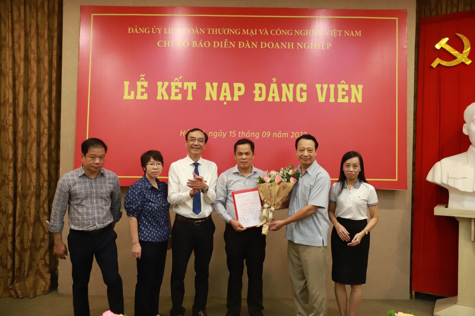 Đồng chí Nguyễn Quang Vinh - Bí thư Đảng ủy, Phó Chủ tịch VCCI và đồng chí Nguyễn Linh Anhp/- Bí thư Chi bộ, Phó Tổng Biên tập phụ trách Tạp chí Diễn đàn Doanh nghiệp trao quyết định và hoa cho đảng viên mới Nguyễn Phước.