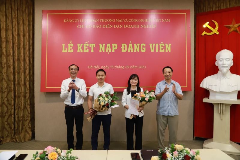 Đồng chí Nguyễn Quang Vinh - Bí thư Đảng ủy, Phó Chủ tịch VCCI và đồng chí Nguyễn Linh Anhp/- Bí thư Chi bộ, Phó Tổng Biên tập phụ trách trao thẻ Đảng cho đồng chí Cao Ngọc Quang và đồng chí Nguyễn Thị Nhung. 