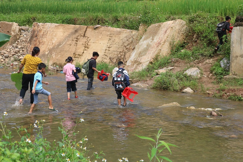 Trẻ em tại Bản Mọc đến trường phải lội qua suối, đặc biệt nguy hiểm trong mùa mưa lũ