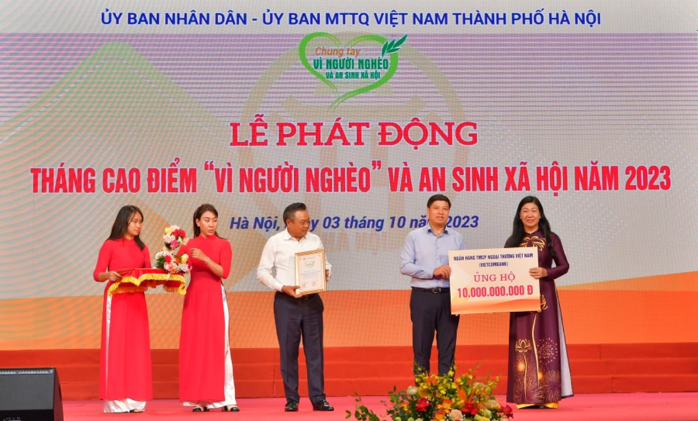 Đồng chí Hồng Quang - Thành viên HĐQT kiêm Giám đốc Khối Nhân sự, Chủ tịch Công đoàn Vietcombank (thứ 2 từ phải sang) trao biển tượng trưng số tiền 10 tỷ đồng ủng hộ “Vì người nghèo” và an sinh xã hộip/Tp Hà Nội năm 2023 cho đồng chí Nguyễn Lan Hương - Chủ tịch Ủy ban MTTQ Việt Nam Tp. Hà Nội và nhận biểu trưng ghi nhận từ đồng chí Trần Sỹ Thanh - Ủy viên Trung ương Đảng, Chủ tịch Ủy ban nhân dân thành phố Hà Nội