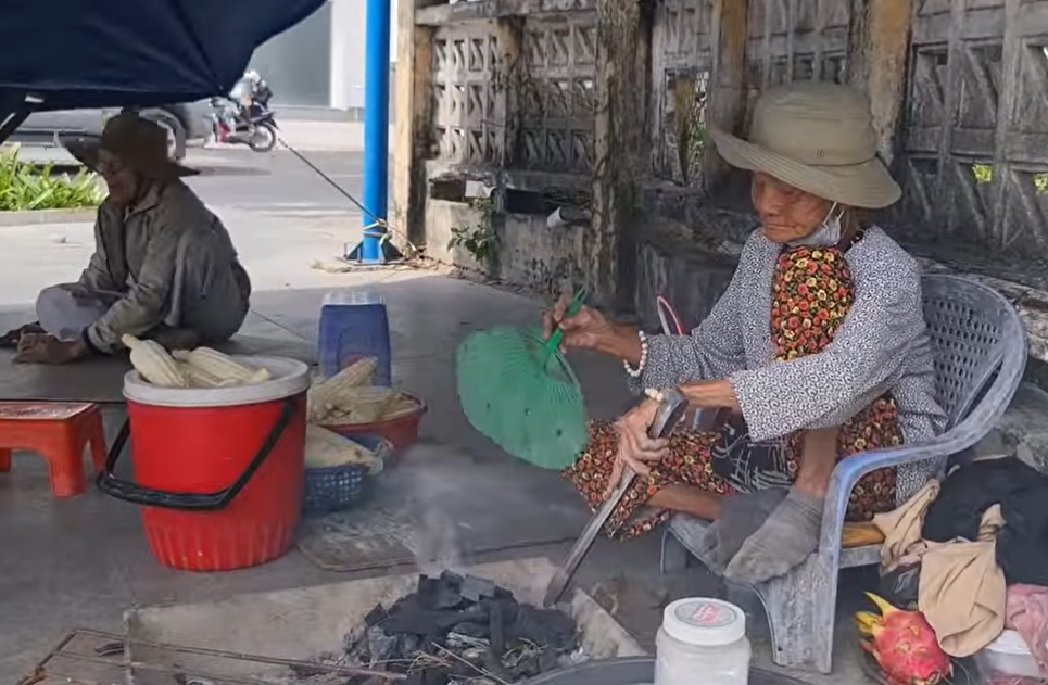 Bà Sáu vẫn hàng ngày chăm chỉ nướng từng trái bắp, củ khoai bán cho khách qua đường để kiếm đủ tiền lo cho cuộc sống hai vợ chồng già