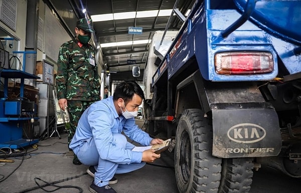 Nhân viên đăng kiểm thực hiện quy trình kiểm định xe cơ giới. (Ảnh: Vietnam+) 