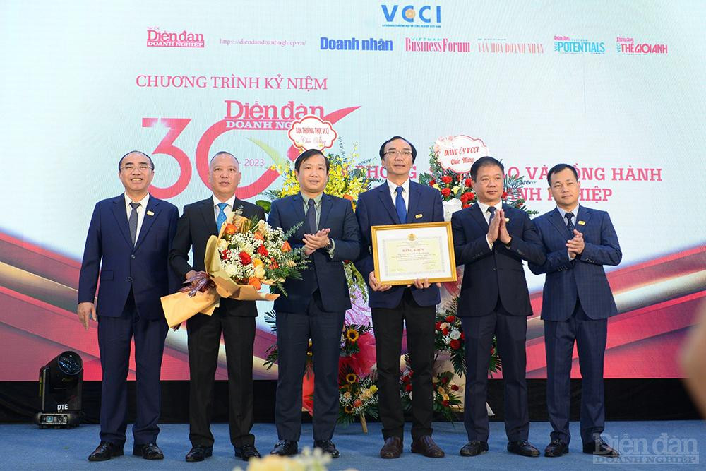 Ông Nguyễn Anh Đức - Chủ tịch Công đoàn VCCI lên sân khấu trao tặng Bằng khen và hoa của Công đoàn Viên chức Việt Nam cho Tạp chí.