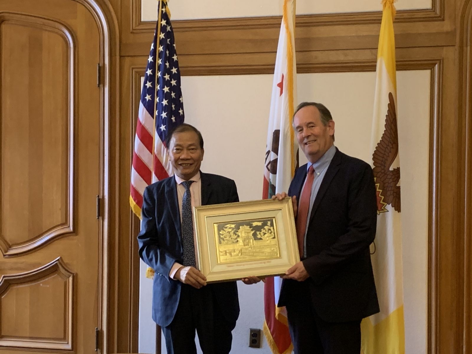 Ông Hoàng Quang Phòng (trái) trao quà lưu niệm của VCCI cho ông Mark Chandler