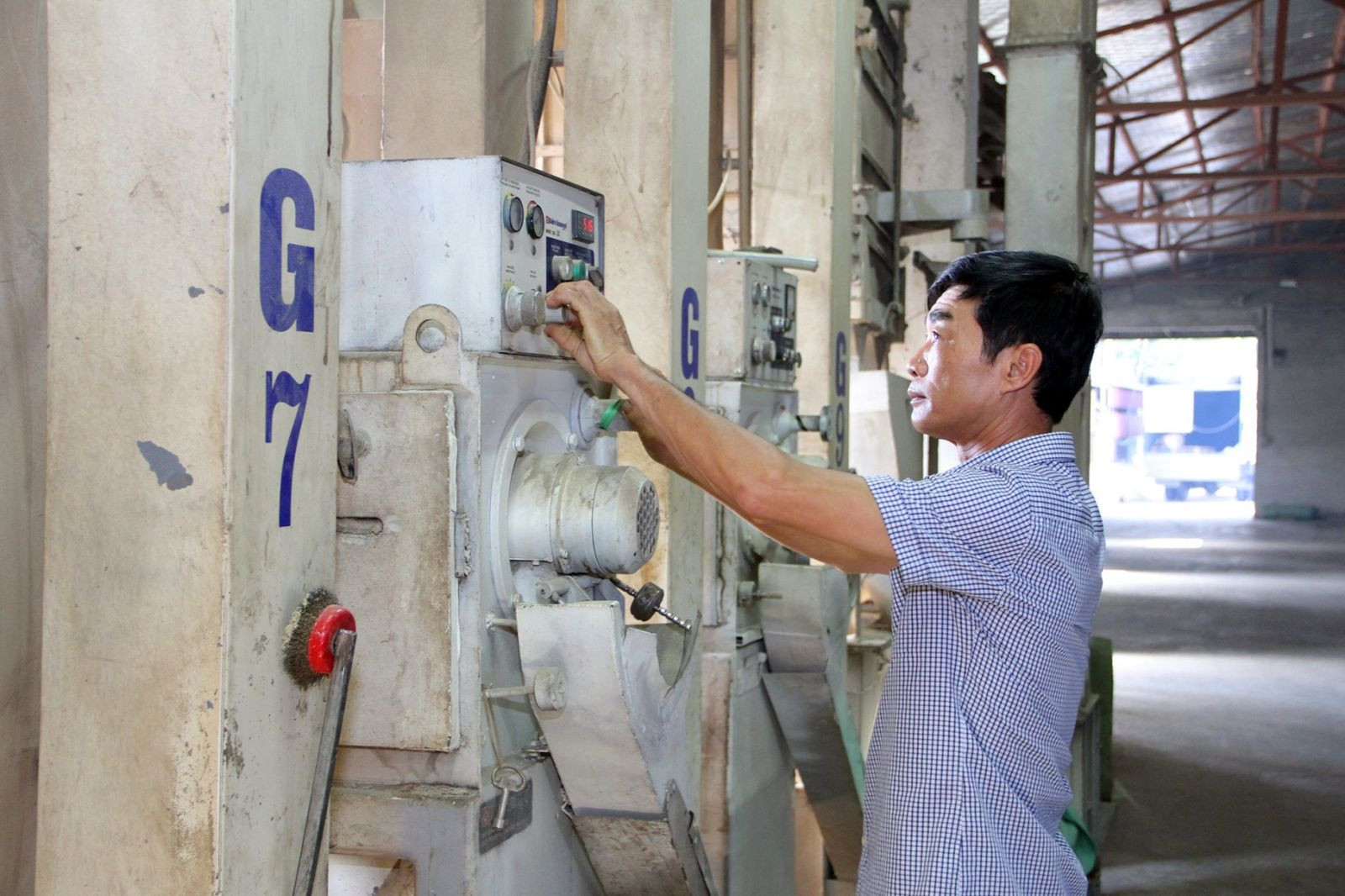 Ông Phan Minh Cường, Giám đốc công ty TNHH sản xuất và kinh doanh lương thực Minh Cường vận hành thiết bị xay xát gạo hiện đại