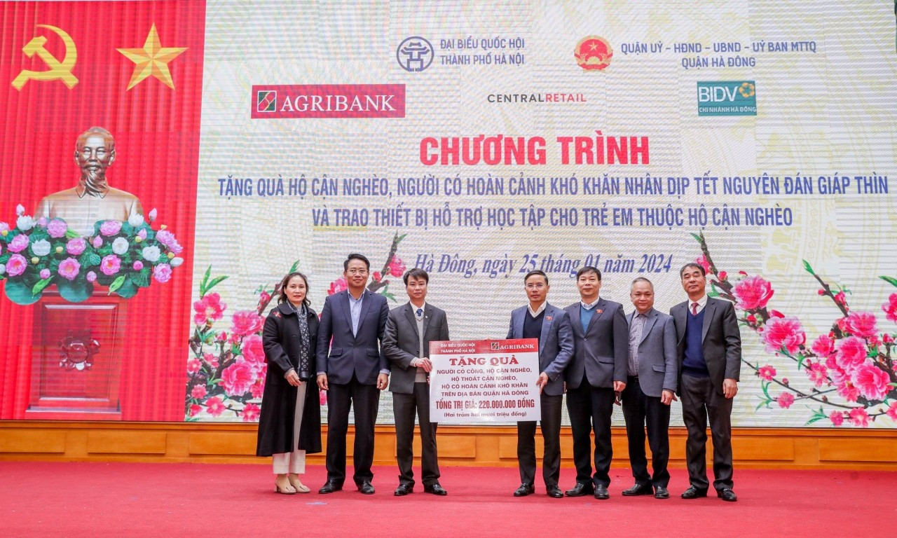 Đồng chí Phạm Đức Ấn - Ủy viên Ban Thường vụ Đảng bộ Khối Doanh nghiệp Trung ương, Bí thư Đảng ủy, Chủ tịch Hội đồng thành viên Agribank trao tặng quà của Agribank hỗ trợ hộ cận nghèo, đối tượng chính sách quận Hà Đông (Hà Nội) nhân dịp Tết Nguyên đán Giáp Thìn