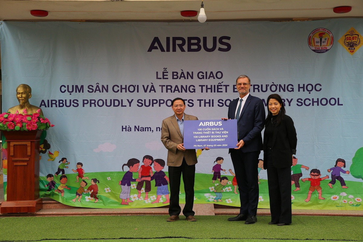 Ông Olivier Brochet, Đại sứ Pháp tại Việt Nam (giữa) và bà Hoàng Tri Mai, Tổng giám đốc Airbus tại Việt Nam (phải), trao tặng sách và trang thiết bị thư viện cho ông Trương Công Sức, Hiệu trưởng Trường Tiểu học Thi Sơn (trái).