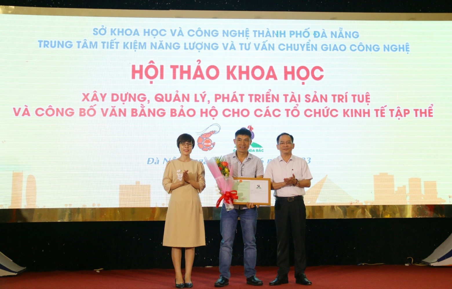 (Ông Lê Đức Viên – Giám đốc Sở KH&CN và bà Nguyễn Thị Thúy - Phụ trách Văn phòng đại diện Cục Sở hữu trí tuệ tại TP.Đà Nẵng trao Giấy chứng nhận nhãn hiệu tập thể “Gà đồi Hòa Bắc”