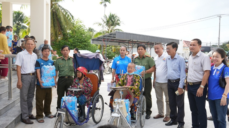 Đại diện Báo CATP, Công ty Tân Hiệp Phát và các đơn vị đồng hành, chính quyền địa phương trao nước cho bà con