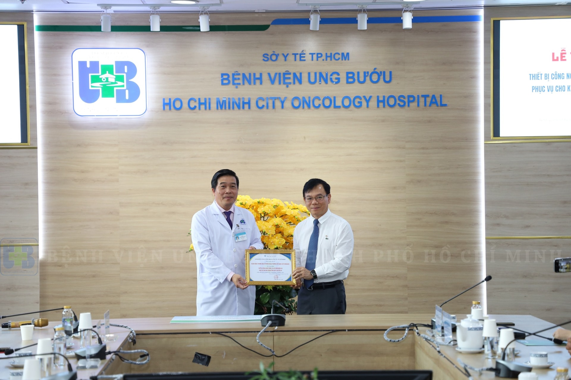 Ông Đặng Hoài Đức - Phó Tổng Giám đốc Vietcombank nhận thư cảm ơn từ đại diện Bệnh viện Ung Bướu TP. HCM - BSCKII. Võ Hồng Minh Phước - Phó Giám đốc Bệnh viện.