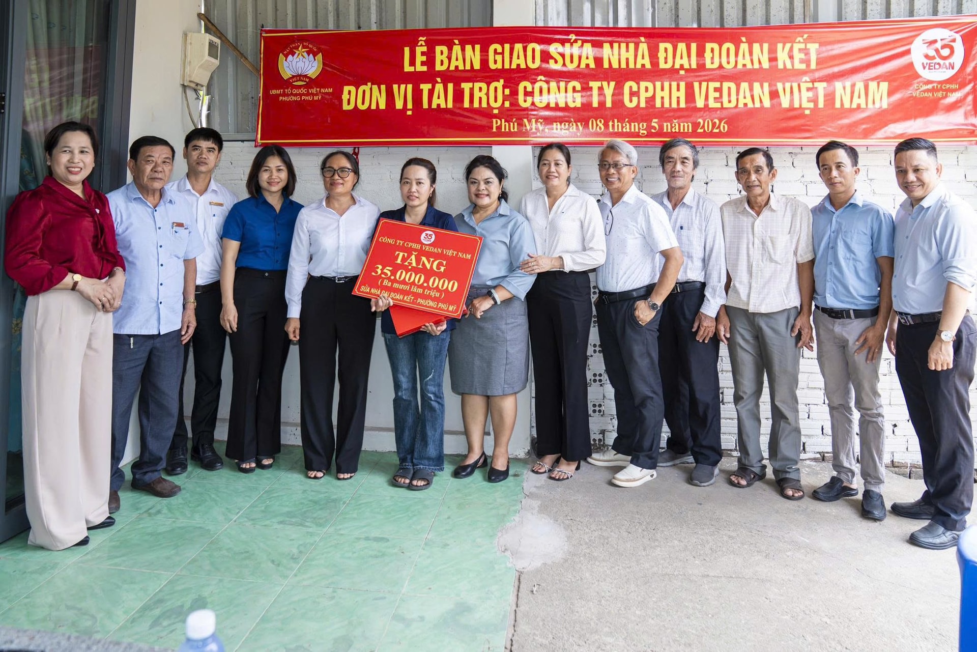 Bà Nguyễn Thu Thủy- Phó giám đốc Vedan Việt Nam ( áo xám ) bàn giao nhà cho gia đình bà Đinh Thị Hiền