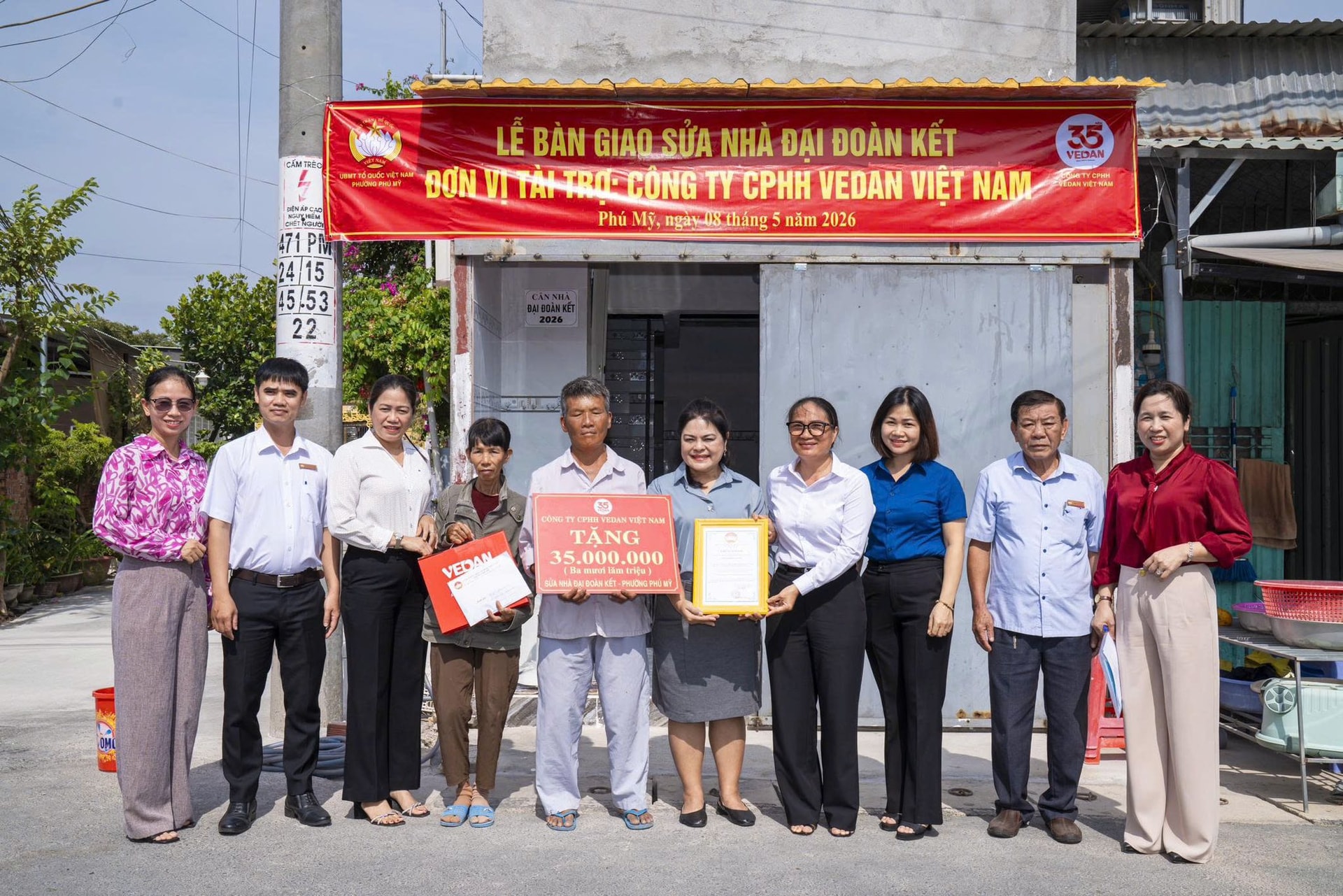 Bà Nguyễn Thu Thủy- Phó giám đốc Vedan Việt Nam ( áo xám ) bàn giao nhà cho gia đình ông Mai Xuân Trường
