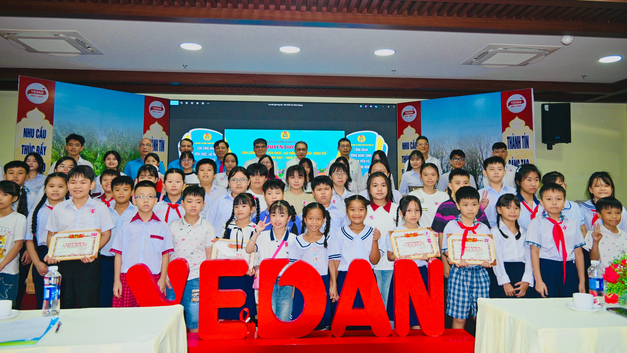 Đại biểu, Ban lãnh đạo Vedan Việt Nam cùng các em học sinh là con CBCNV chụp ảnh lưu niệm tại lễ tuyên dương, khen thưởng năm học 2025–2026