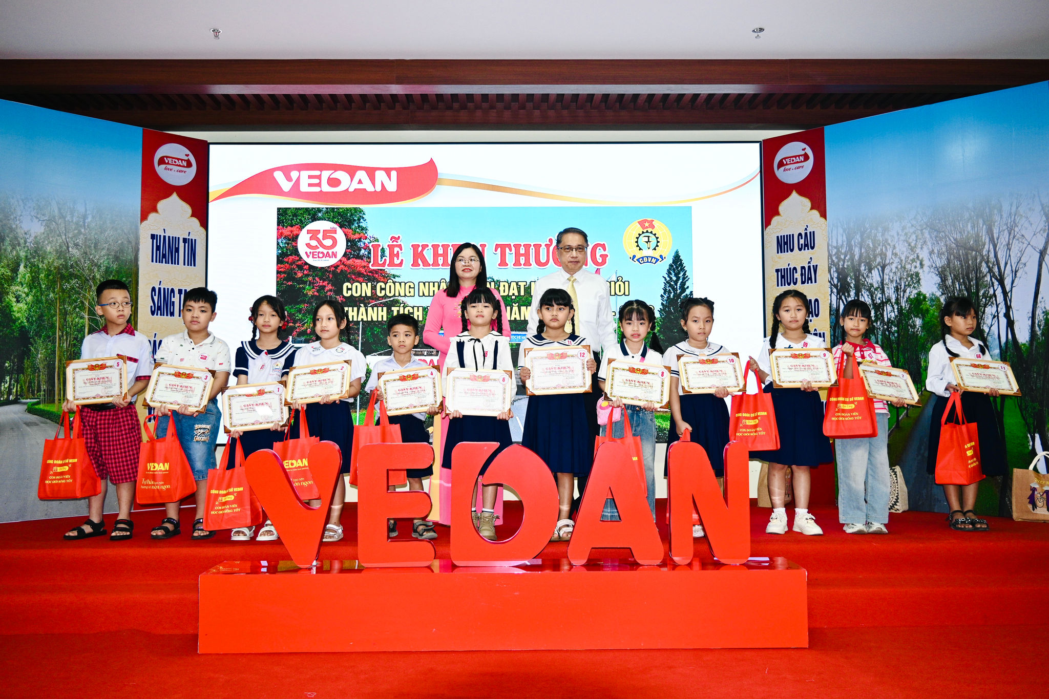 Phó Chủ tịch Liên đoàn Lao động TP. Đồng Nai Nguyễn Thị Tuyết và Tổng Giám đốc Vedan Việt Nam Ni Chih Hao trao thưởng cho các em học sinh đạt thành tích xuất sắc