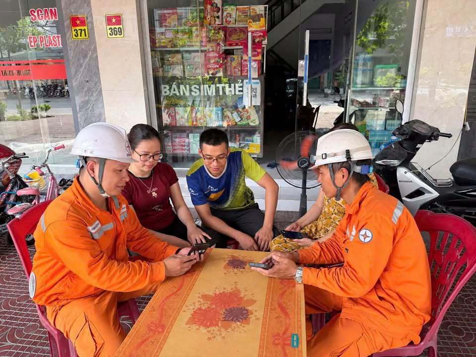 Nhân viên Điện lực Đông Triều, CTĐL Quảng Ninh tuyên truyền, hướng dẫn khách hàng cài đặt ứng dụng EVN CSKH