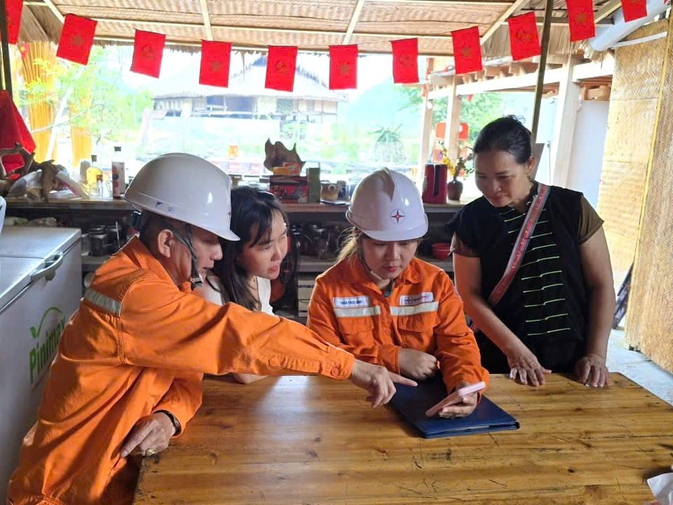 Cán bộ nhân viên Điện lực Hà Giang hướng dẫn người dân cách xem tiền điện trên ứng dụng Chăm sóc khách hàng của ngành Điện.