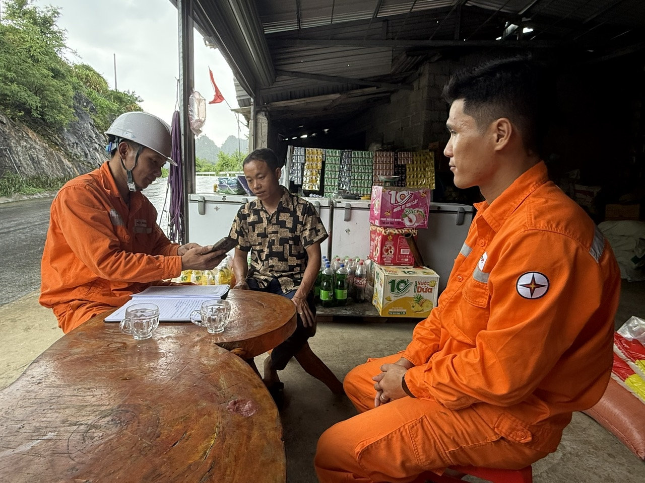 Cán bộ nhân viên Điện lực Mèo Vạc tuyên truyền hướng dẫn người dân sử dụng ứng dụng Chăm sóc khách hàng của ngành điện trên điện thoại thông minh.