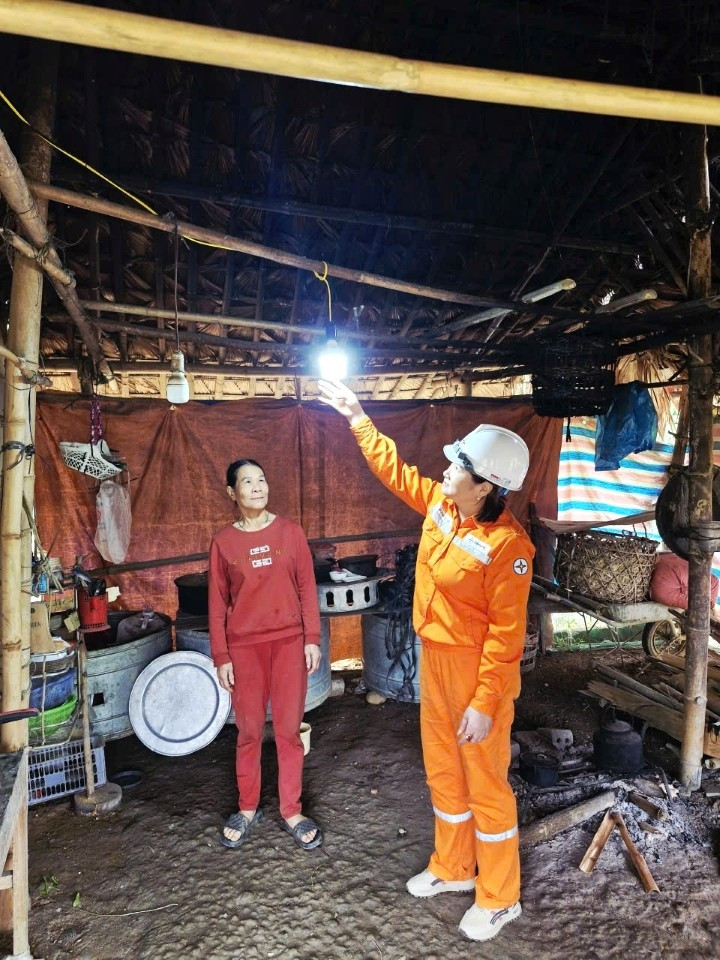 Nhân viên Điện lực Bắc Quang hỗ trợ người dân xã Đồng Tâm lắp đặt bóng đèn.
